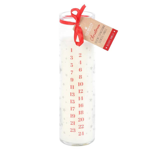 A tall white Advent candle in a glass holder, featuring a vanilla fragrance, silver stars, and red numbers 1–24. A red ribbon and brown Christmas tag are tied at the top for festive charm.