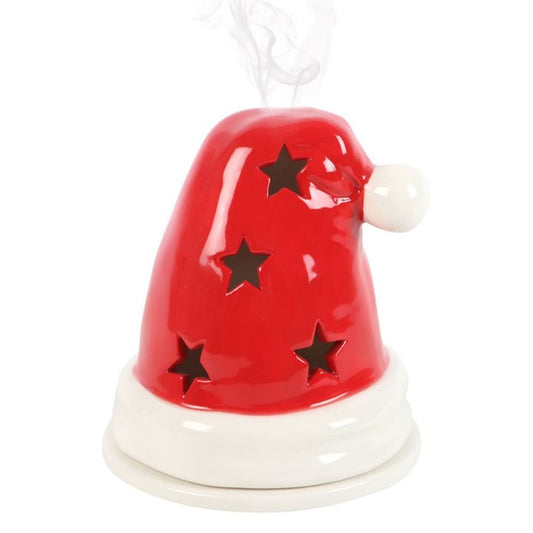 A red ceramic ornament in the shape of Santa’s hat, featuring a white brim and star-shaped cut-outs. Light smoke rises from the top, making it ideal as an incense cone burner or a festive candle holder.
