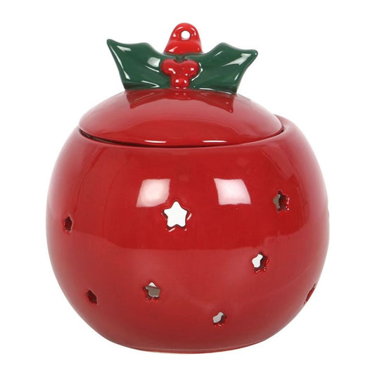 A round, red ceramic jar with star-shaped cut-outs and a lid adorned with green holly leaves and berries. Resembling a red bauble oil burner, its glossy finish exudes a charm perfect for any Christmas decoration.