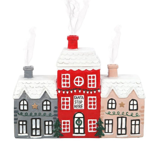 A ceramic Christmas house incense burner featuring three sections, snow-covered roofs, and smoke curling from the chimneys. The central red house bears the message Santa Stop Here, while the side houses are festively decorated in grey and beige.