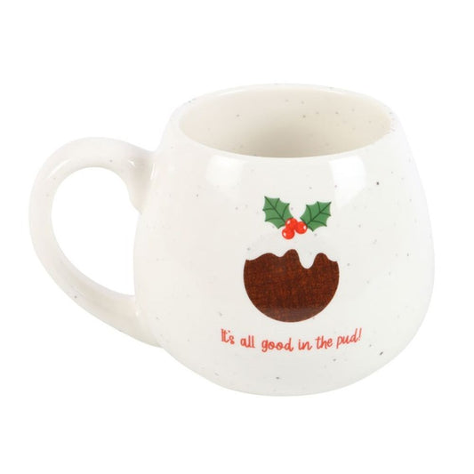 A white, rounded ceramic Christmas pudding mug with grey speckles features a festive pudding illustration topped with holly and the words Its all good in the pud! written in red beneath the design.