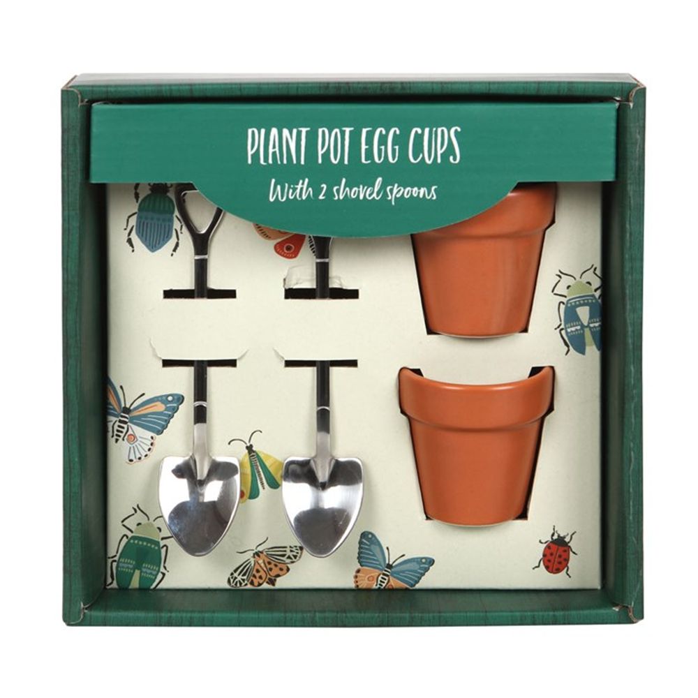 Box set of plant pot egg cups, featuring two terracotta-style cups and shovel spoons. A kitchen essential with packaging adorned with insects, it reads Plant Pot Egg Cups with 2 Shovel Spoons in white text on a green background.