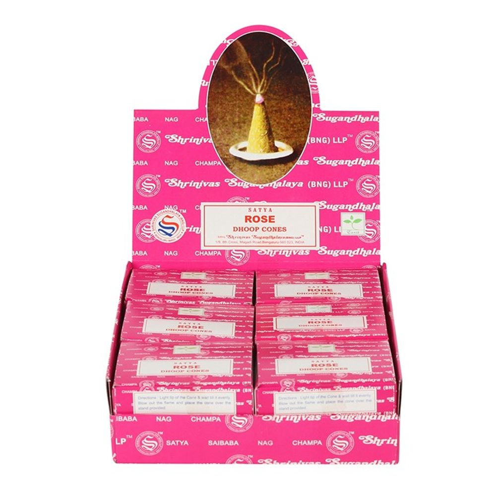 A pink display box features multiple packs of Satya Rose Dhoop Cones, crafted with quality ingredients. The open box reveals a lit cone with smoke wafting upwards. Inside, the neatly aligned packs showcase their signature fragrance.