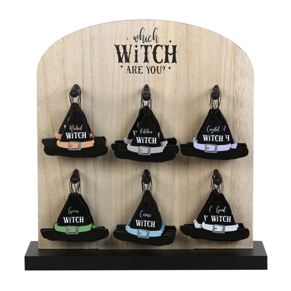 A wooden countertop display labelled ‘Which Witch Are You?’ holds six small black witches’ hats with enchanting designs and colourful bands, each label featuring playful witch titles such as Basic Witch, Crystal Witch, and more.