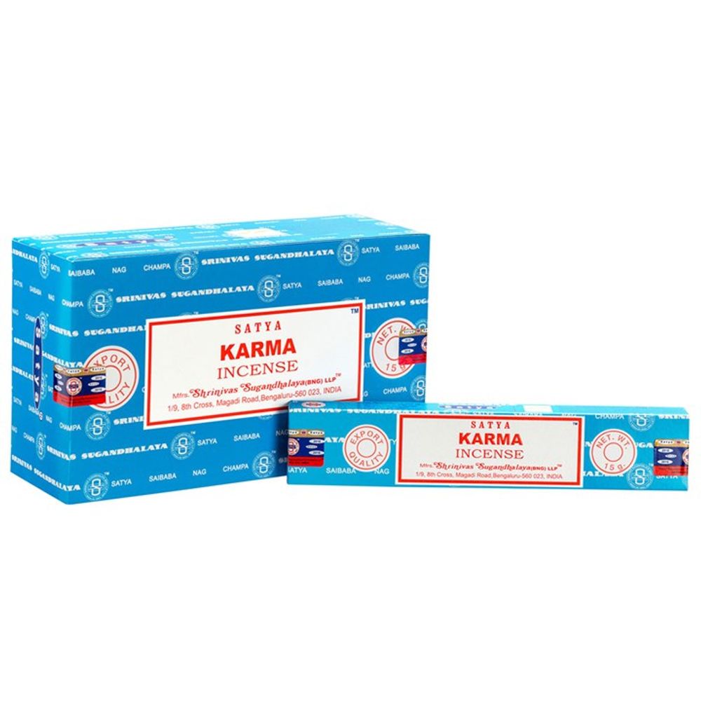 Two boxes of Satya Karma incense are displayed. The larger box stands upright, decorated with blue, red, and white patterns featuring the Satya logo. The smaller box lies horizontally in front and shares similar colours, branding the floral scent as handmade in India.