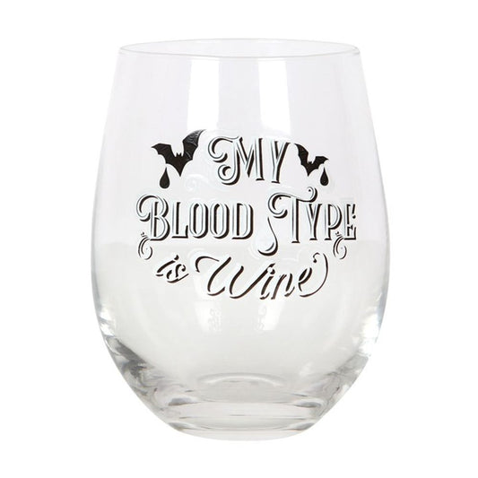 This stemless wine glass, embellished with black gothic bat designs and the whimsical text My Blood Type is Wine, suggests a preference for red wine. The empty glass exudes charm against a stark white background.
