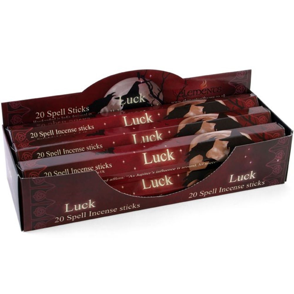 A display box contains multiple packs of Luck Spell Incense sticks. Designed in deep red with a mystical theme, it features Lisa Parkers enchanting artwork. Each pack, labelled 20 Spell Incense sticks, highlights a hand holding cards, evoking the promise of good fortune.