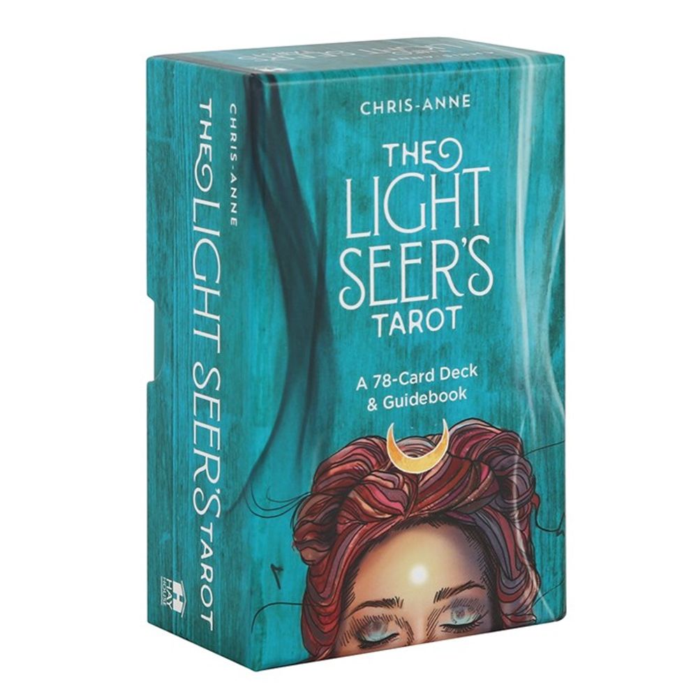 A boxed set of The Light Seers Tarot by Chris-Anne. The teal box features an illustration of a person with closed eyes and red hair, crowned with a golden crescent. This tarot card deck includes 78 cards and an insightful guidebook.