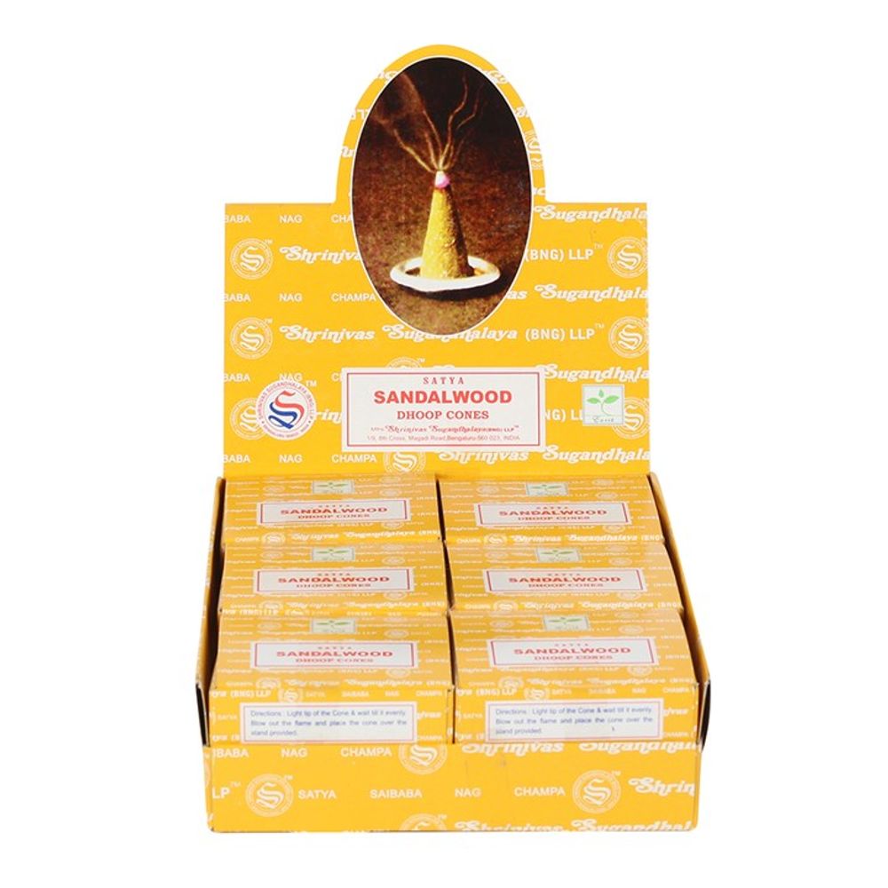 The image shows an open display box containing several small boxes of Satya Sandalwood incense cones. The packaging, adorned with a floral motif, is predominantly orange. Above the display is an oval image of a burning cone, highlighting its long-lasting fragrance. The brand Satya appears on each box.