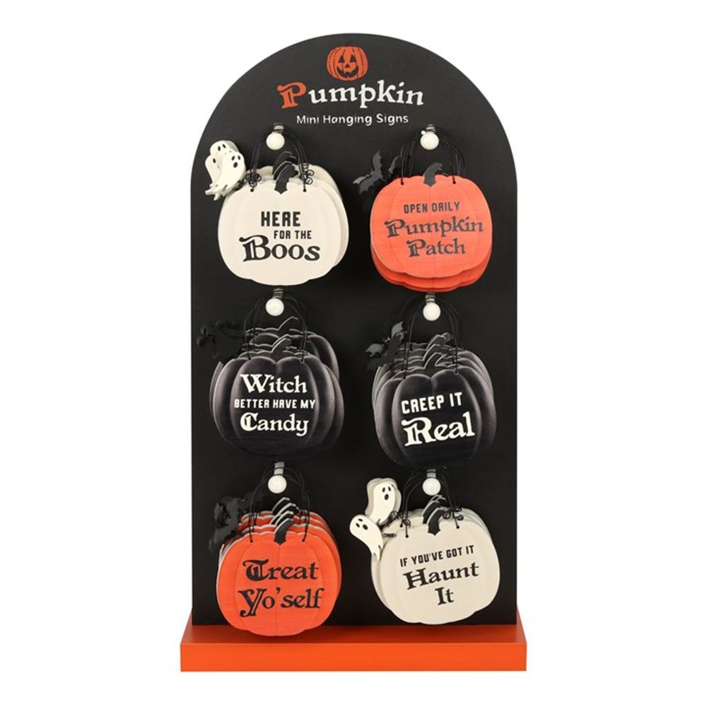A display stand holds six wholesale, pumpkin-shaped signs with Halloween phrases such as “Here for the Boos”, “Pumpkin Patch”, “Witch Better Have My Candy”, and more.