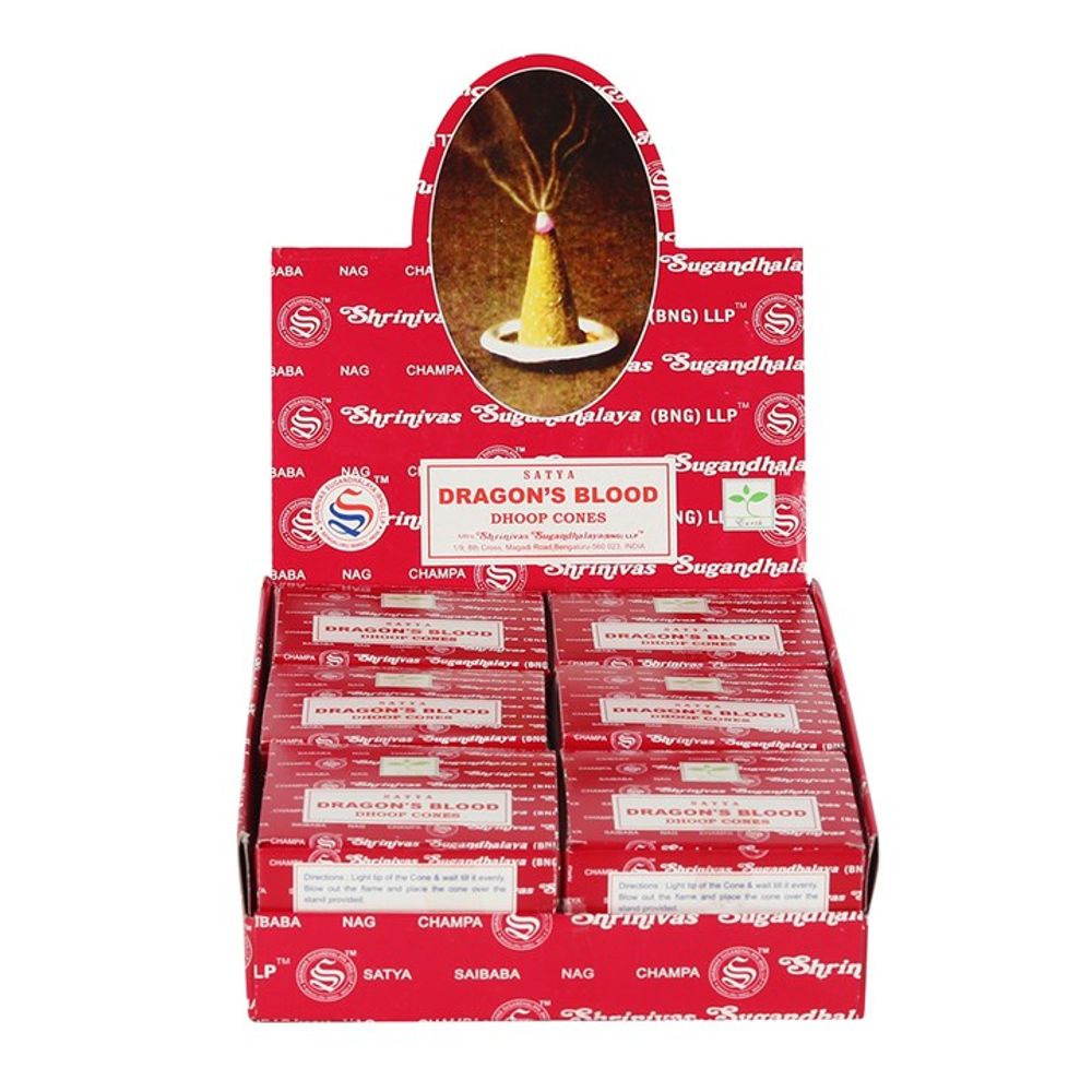 The red display box, adorned with white text and logos, showcases Satya Dragons Blood incense cones. Several smaller boxes are neatly arranged inside. Above, an oval image highlights the use of these incense cones known for their long-lasting fragrance.