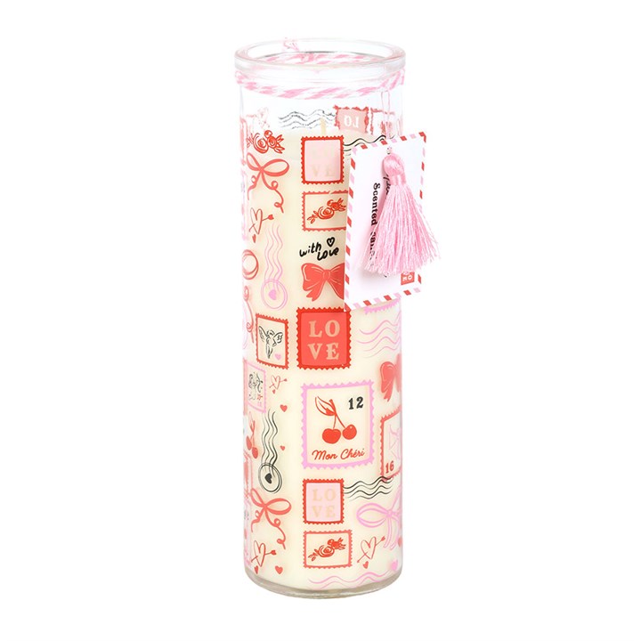 Tall glass tube candle with postage stamp prints in pink and red, featuring love-themed stamps, cherries, hearts, and bows. Infused with a sparkling rose scent—ideal as a Valentine’s gift. White tag with pink tassel; white wax inside.