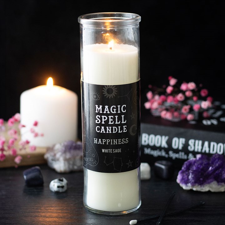 A lit Happiness Magic Spell candle—white sage ritual candle—stands on a dark surface. Crystals, a burning white candle, pink flowers, and a “Book of Shadows” complete the mystical scene.