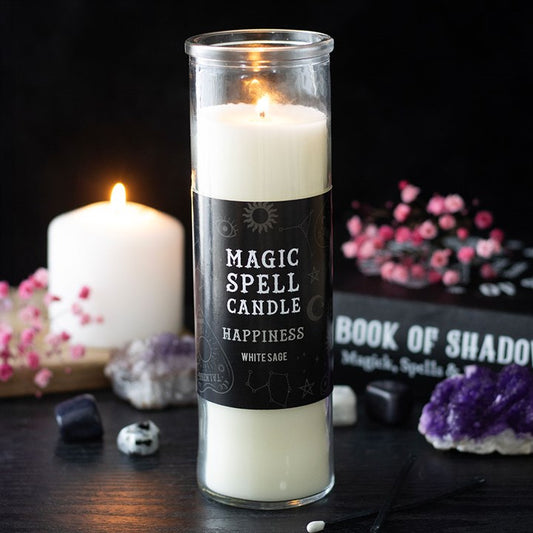 A lit Happiness Magic Spell candle—white sage ritual candle—stands on a dark surface. Crystals, a burning white candle, pink flowers, and a “Book of Shadows” complete the mystical scene.