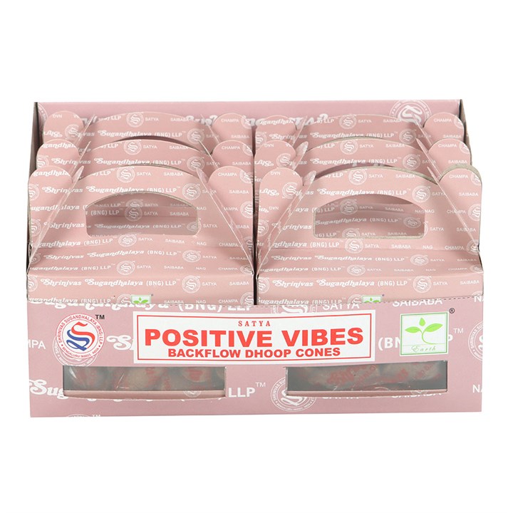 A pink cardboard display box holds several packs of Satya Positive Vibes fragrance dhoop backflow incense cones. The label features red and white text, with the packages neatly arranged upright in two rows.