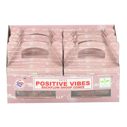 A pink cardboard display box holds several packs of Satya Positive Vibes fragrance dhoop backflow incense cones. The label features red and white text, with the packages neatly arranged upright in two rows.
