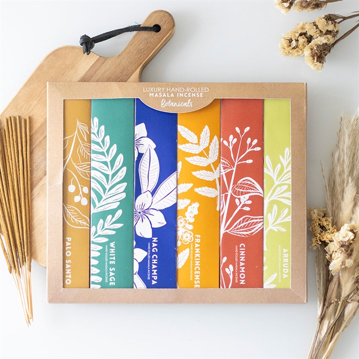 A box of six luxury, hand-rolled masala incense sticks made with organic ingredients—Palo Santo, White Sage, Nag Champa, Frankincense, Cinnamon and Arruda. Colourful packaging features botanical illustrations. Suitable for vegans.