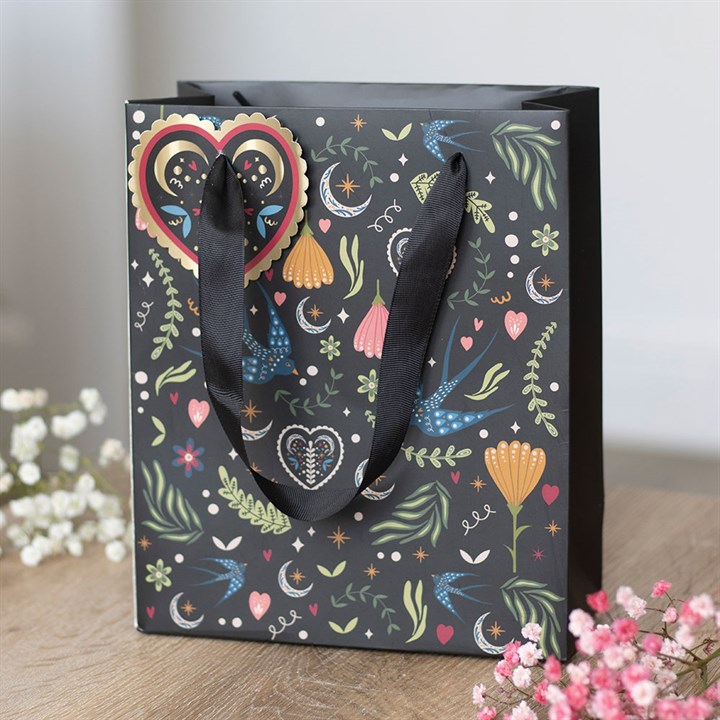 A medium-sized black gift bag, adorned with a heart and an attractive floral print—ideal for any special occasion.