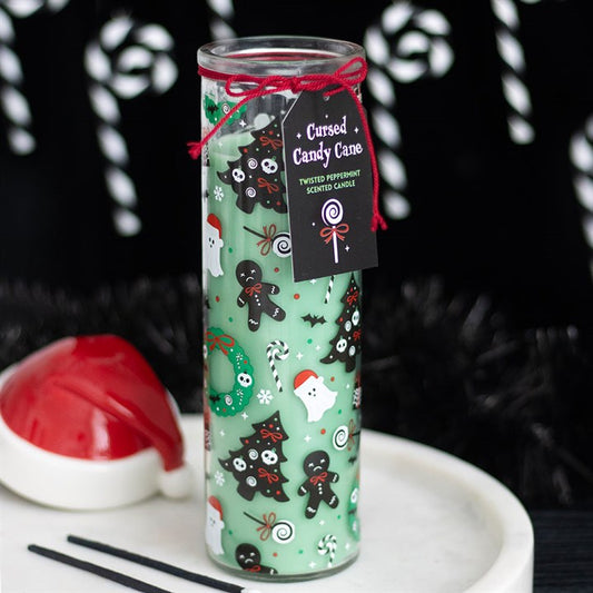 A tall green Cursed Candy Cane candle decorated with ghosts, black cats, bats, and haunted gingerbread men. A black tag tied with red string displays its twisted peppermint fragrance.