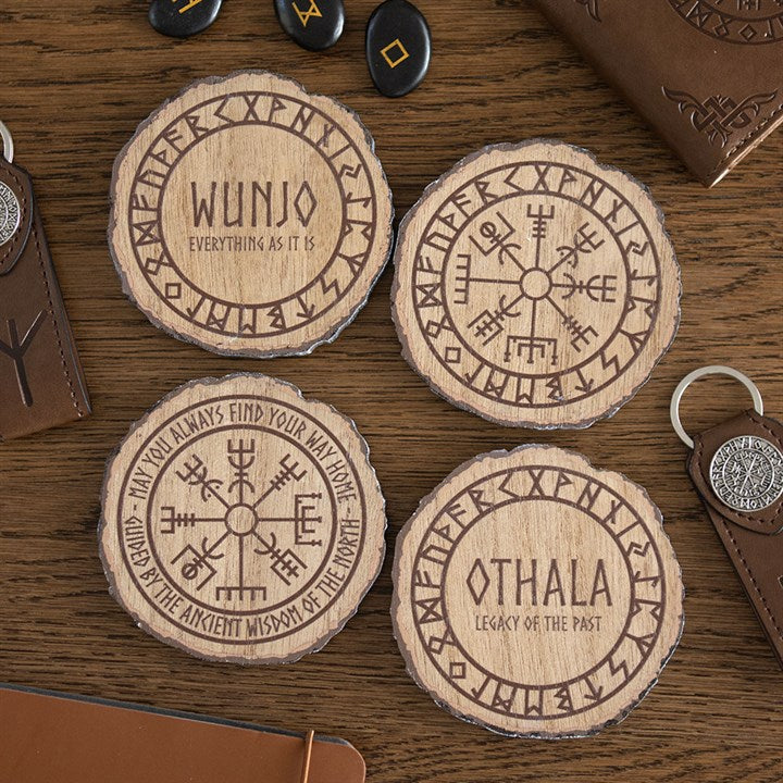 Four circular Viking rune coasters bearing Norse symbols sit on a wooden table. Two read “Wunjo: Everything as it is” and “Othala: Legacy of the Past”; two display detailed rune motifs and circular inscriptions.