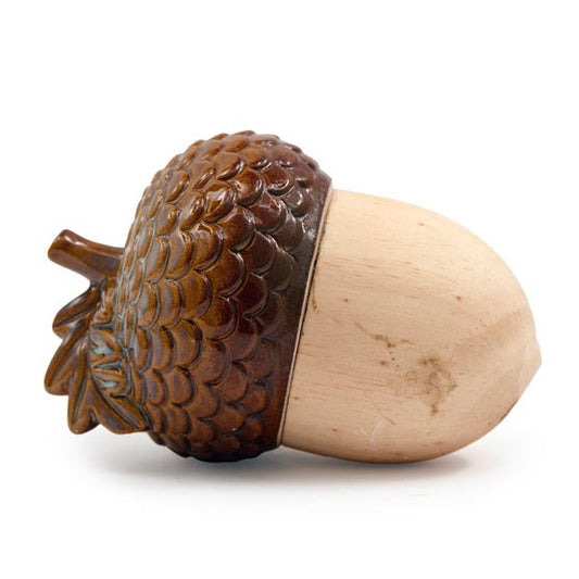 A realistic wooden acorn ornament with a smooth, light-coloured base and a dark brown, textured cap, lying on its side—perfect as natural home décor against a white background.