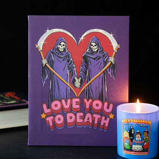 An ideal gift for a goth couple, this purple card features two Grim Reapers holding hands, their scythes forming a heart. LOVE YOU TO DEATH is boldly written underneath, with a lit candle in a cartoon mug in the foreground.