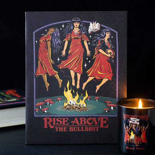 An illustration depicts three witches in red dresses floating above a campfire, surrounded by mushrooms, with a flying book overhead—perfect witchy décor or a retro gift in the style of a Steven Rhodes canvas.