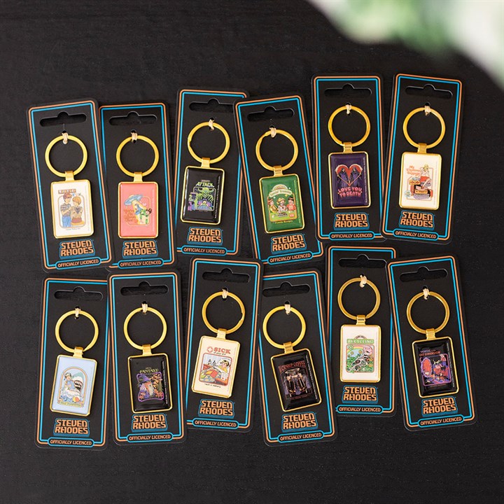 Twelve Steven Rhodes keyrings with retro-style illustrated designs are displayed on a black surface, each in its packaging with a gold ring and enamel keyring charm featuring quirky artwork and text—ideal retro gifts.