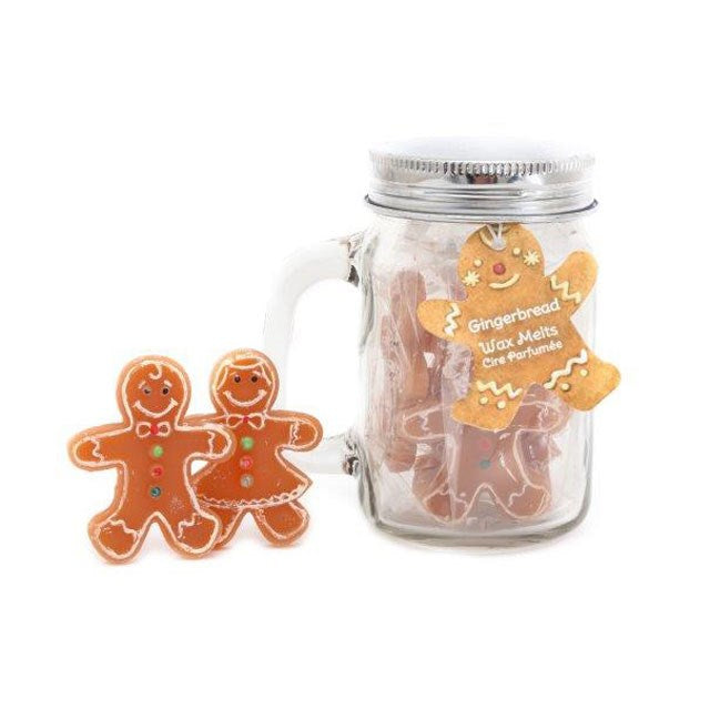A glass Kilner jar with a silver lid contains gingerbread-shaped wax melts. A gingerbread tag reads “Gingerbread Wax Melts.” Two decorated figures sit in front—ideal for festive décor and a cosy Christmas aroma.