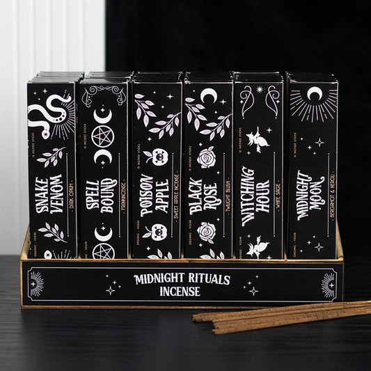 A box contains six black incense packs adorned with mystical white designs: Snake Venom, Spell Bound, Poison Apple, Black Rose, Witchling, Midnight Moon. Vegan-friendly incense sticks and a mesmerising fragrance await within.