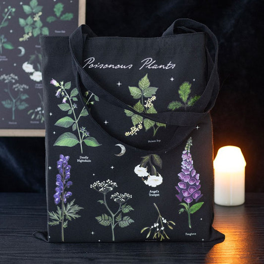 A reusable polycotton tote bag featuring an eco-friendly poisonous plant design, with illustrations of Bittersweet Nightshade, Poison Ivy, Angel’s Trumpet, and Foxglove. The bag rests beside a lit candle on a dark surface.