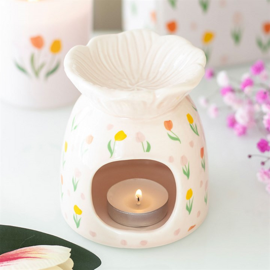 A candle in a tulip-patterned pot.