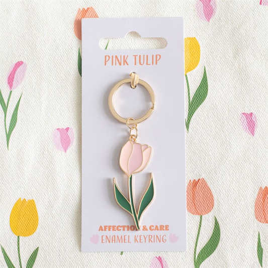 A gold and pink tulip keyring with an enamel charm sits on a “Pink Tulip” card, placed against a floral background—an ideal floral keyring and thoughtful gift for Mother’s Day.