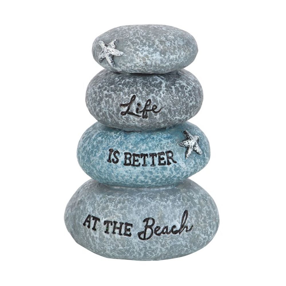 A stack of four textured, greyish-blue stones adorned with small starfish decorations serves as a delightful beach ornament. Each stone, decreasing in size from top to bottom, bears the phrase Life is better at the beach, making it a perfect holiday memento for seaside lovers.